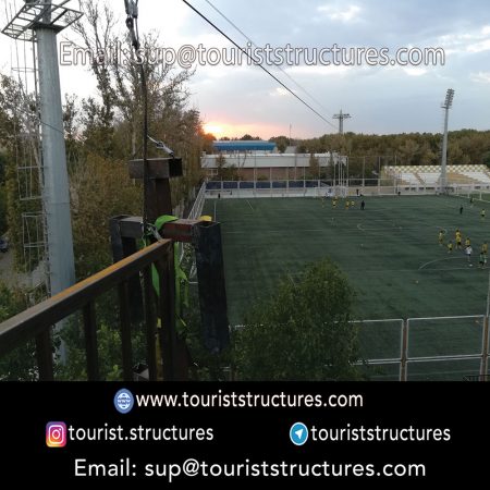 zipline, Photo on the right: zip line ascent platform from a height of 42 meters, Photo on the left: zip line landing platform at a height of 12 meters, In this zip line not used of natural slope (unlike more than 90% of the zip lines of the world) and height difference has been created by metal towers. This zip line height is 450 meters and this is the biggest (tower to tower) zip line in the world, Lighting and its beautiful appearance at night (photo on the right) is one of the most important options, The zip line of Isfahan Ferdows Garden with a height 450 meters due to presence of dense trees, it was very difficult to implement, but we have tried not to damage the trees during the implementation, A View of the tower ascent and descend of the zip line in a picture in Ferdows Garden of Isfahan, Successful zip line test by metal mannequin